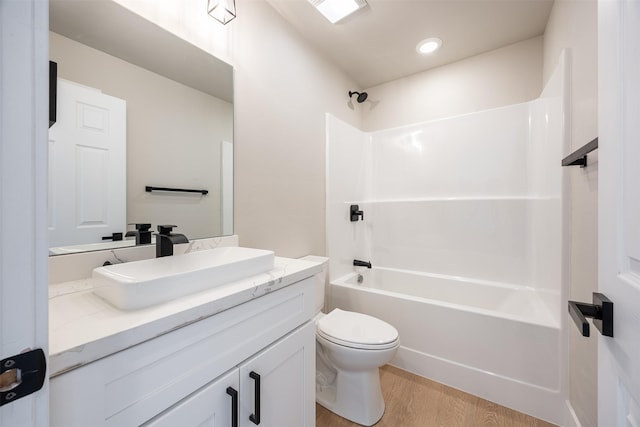 full bathroom with toilet, washtub / shower combination, wood-type flooring, and vanity