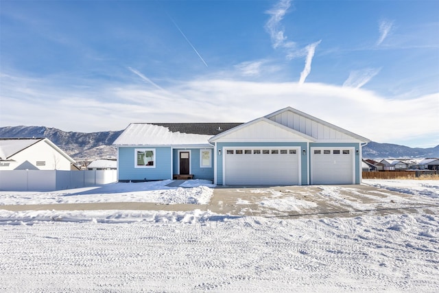 ranch-style home with a garage and a mountain view