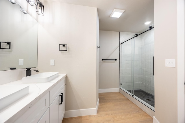 bathroom featuring walk in shower, hardwood / wood-style floors, and vanity