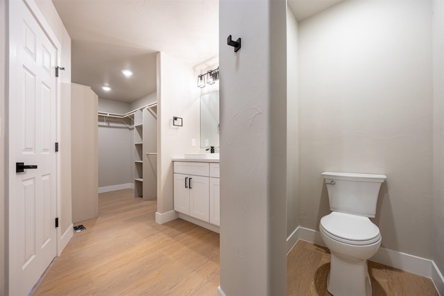 bathroom featuring toilet, vanity, and hardwood / wood-style floors