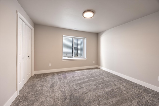 spare room with dark carpet