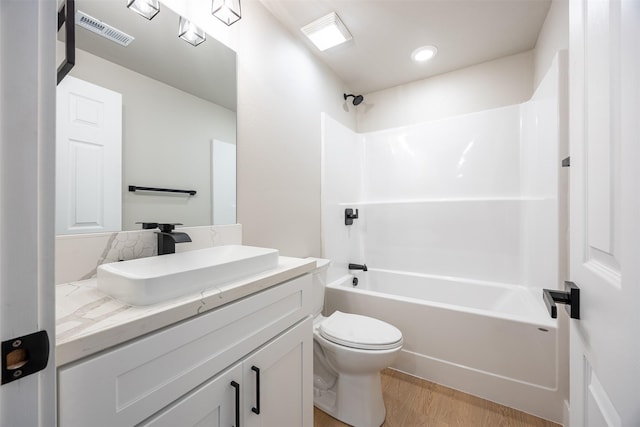 full bathroom with toilet, shower / bathing tub combination, wood-type flooring, and vanity