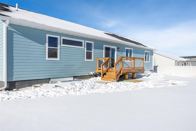 snow covered house with a deck