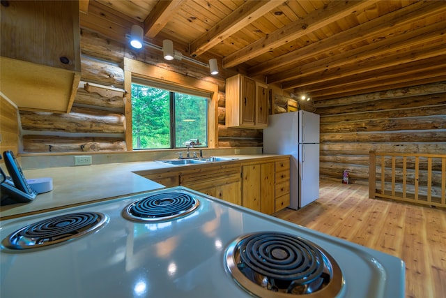 kitchen with white fridge, rustic walls, sink, wooden ceiling, and light hardwood / wood-style floors