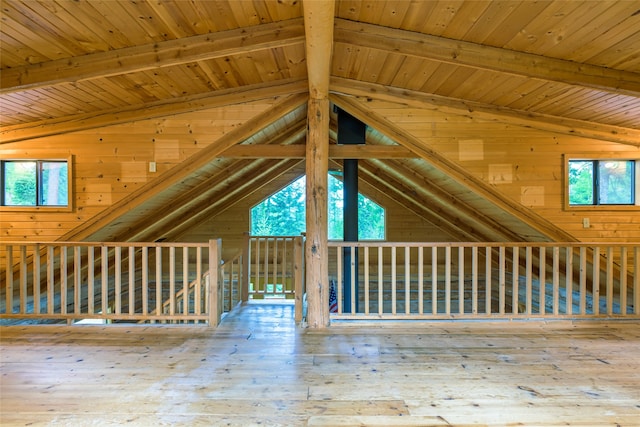 bonus room with a wealth of natural light, hardwood / wood-style flooring, and vaulted ceiling with beams