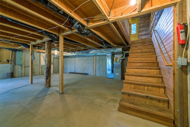 basement featuring electric panel and heating unit