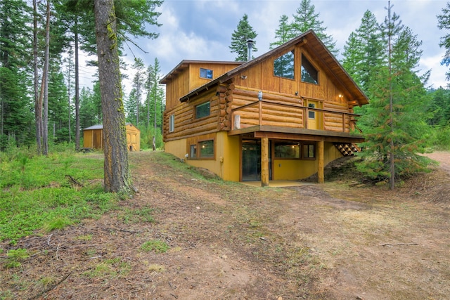 rear view of property featuring a storage unit