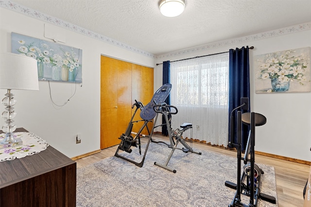 workout area featuring a textured ceiling and hardwood / wood-style flooring