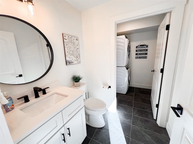 bathroom featuring vanity, toilet, stacked washer / drying machine, and tile patterned floors