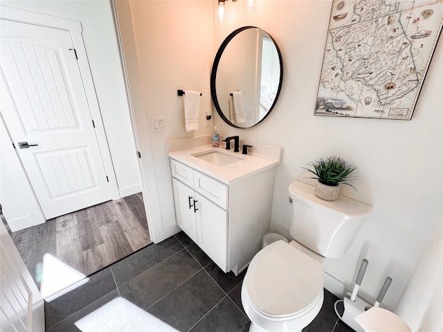 bathroom with tile patterned flooring, toilet, and vanity