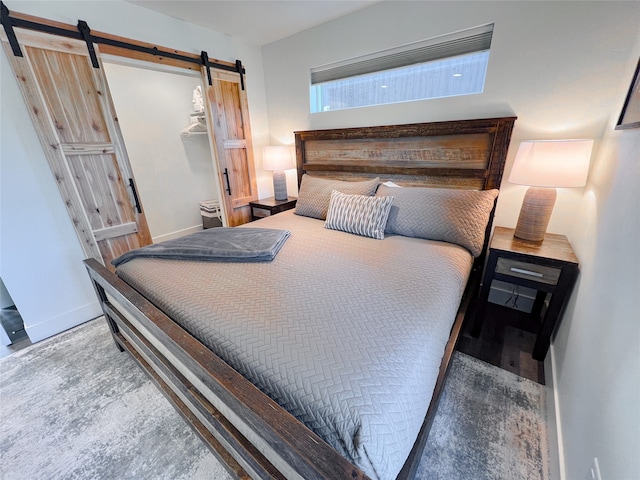 bedroom with a barn door and a walk in closet