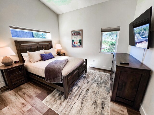 bedroom with lofted ceiling and light hardwood / wood-style floors