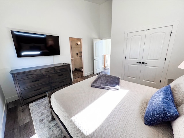 bedroom with dark wood-type flooring, a high ceiling, and a closet