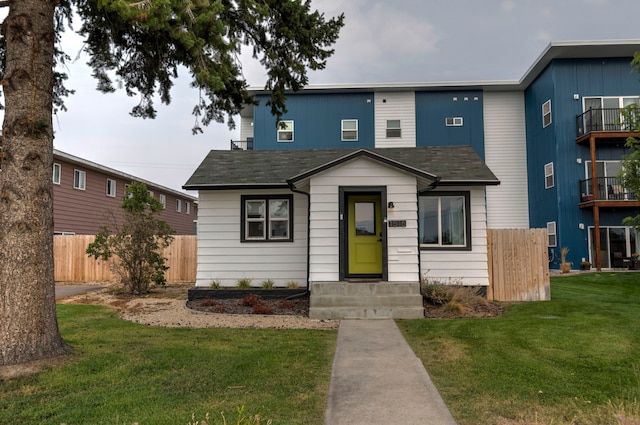 view of front facade featuring a balcony and a front lawn