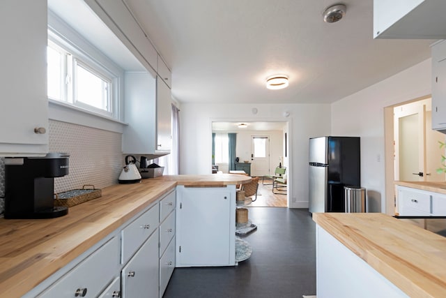 kitchen with stainless steel refrigerator, white cabinets, dark hardwood / wood-style flooring, and butcher block counters