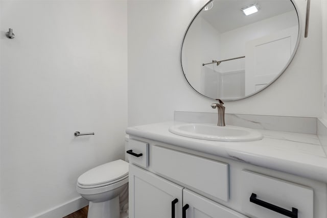 bathroom featuring vanity, toilet, wood-type flooring, and walk in shower