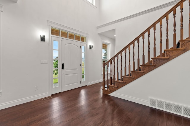 entryway with dark hardwood / wood-style floors and a high ceiling