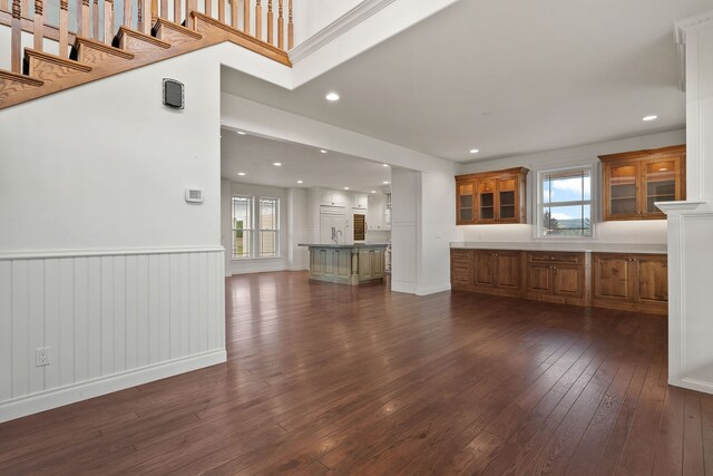 unfurnished living room featuring dark wood-type flooring and a wealth of natural light