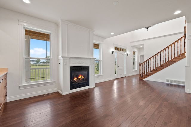 unfurnished living room featuring dark hardwood / wood-style flooring and a healthy amount of sunlight