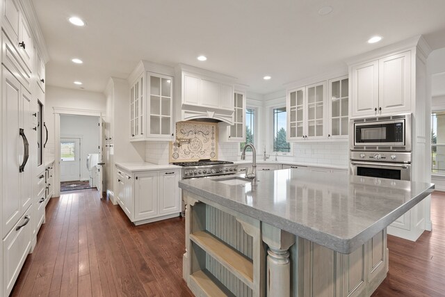 kitchen with sink, white cabinetry, appliances with stainless steel finishes, a kitchen breakfast bar, and dark hardwood / wood-style flooring