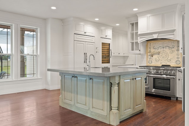 kitchen featuring sink, a center island with sink, high end appliances, and dark hardwood / wood-style flooring