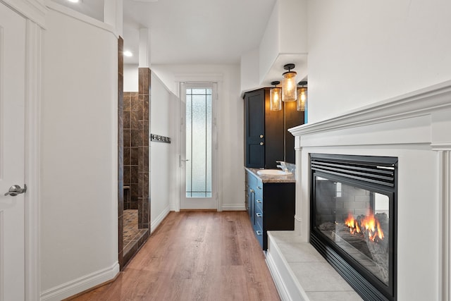 interior space with a shower, vanity, and hardwood / wood-style flooring