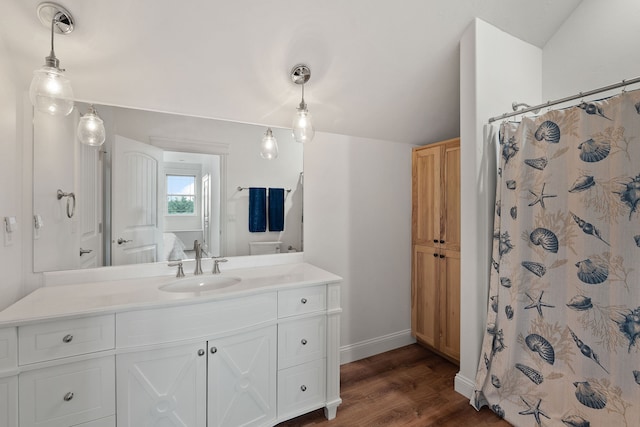 bathroom featuring vanity, vaulted ceiling, and hardwood / wood-style flooring