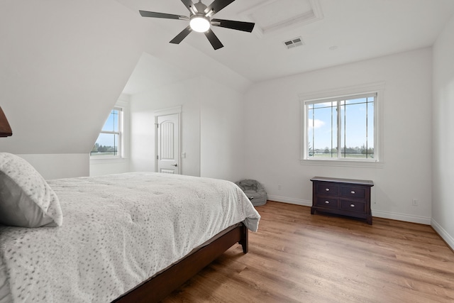 bedroom featuring light hardwood / wood-style floors, lofted ceiling, and ceiling fan