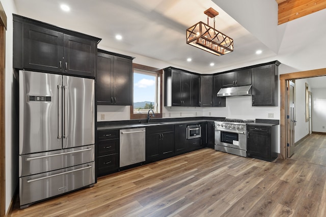 kitchen featuring pendant lighting, high end appliances, hardwood / wood-style floors, and sink