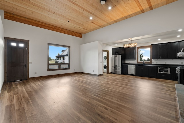 unfurnished living room featuring wood ceiling, stacked washer and dryer, and dark wood-type flooring