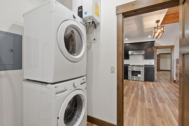 washroom with electric panel, light wood-type flooring, and stacked washer / drying machine