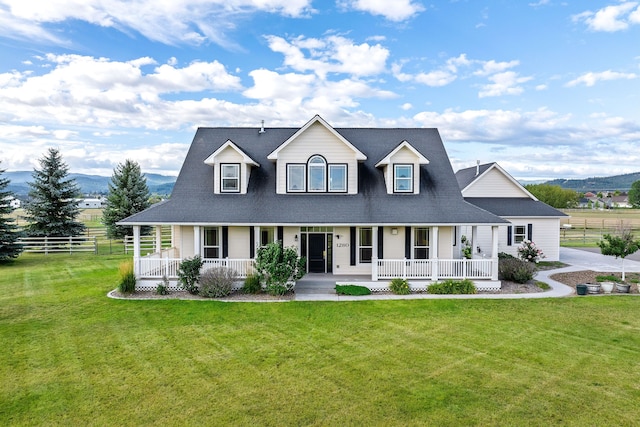 view of front of house featuring a mountain view, a front lawn, and a porch