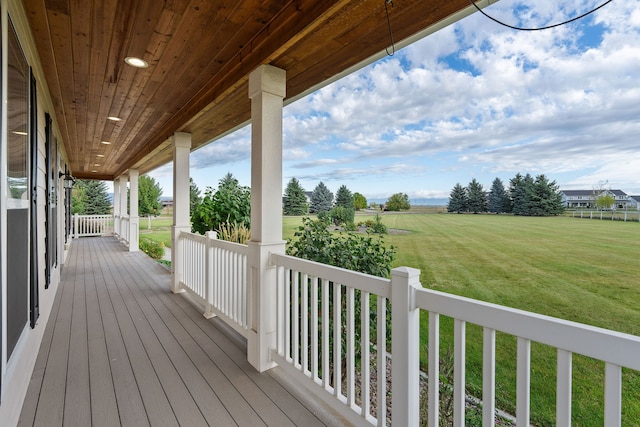 wooden deck featuring a lawn and covered porch