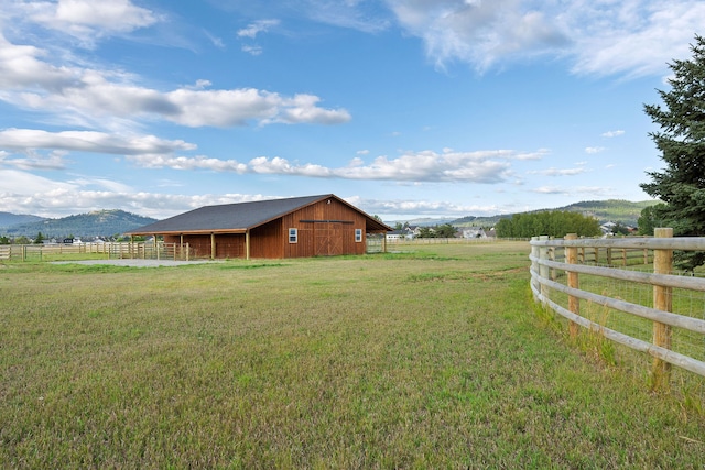 view of yard with a mountain view, an outdoor structure, and a rural view