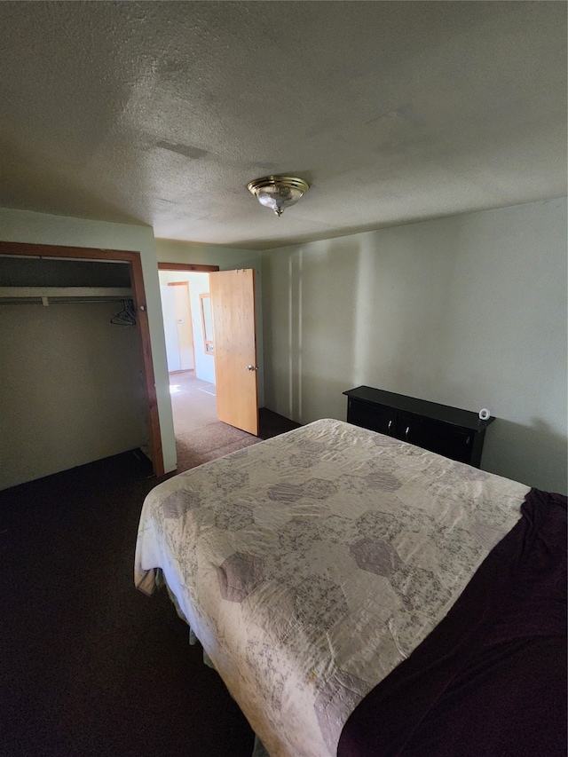 bedroom featuring a closet, a textured ceiling, and carpet floors