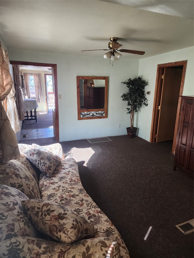 unfurnished living room with a textured ceiling, carpet flooring, and ceiling fan