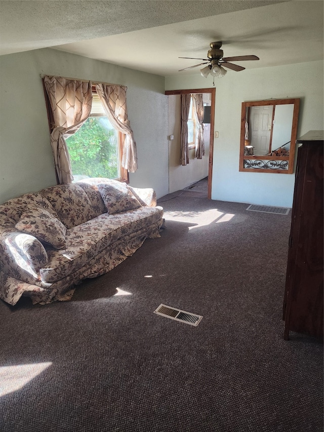 unfurnished living room featuring ceiling fan, carpet, and a textured ceiling