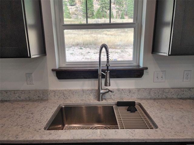 details featuring light stone countertops and sink