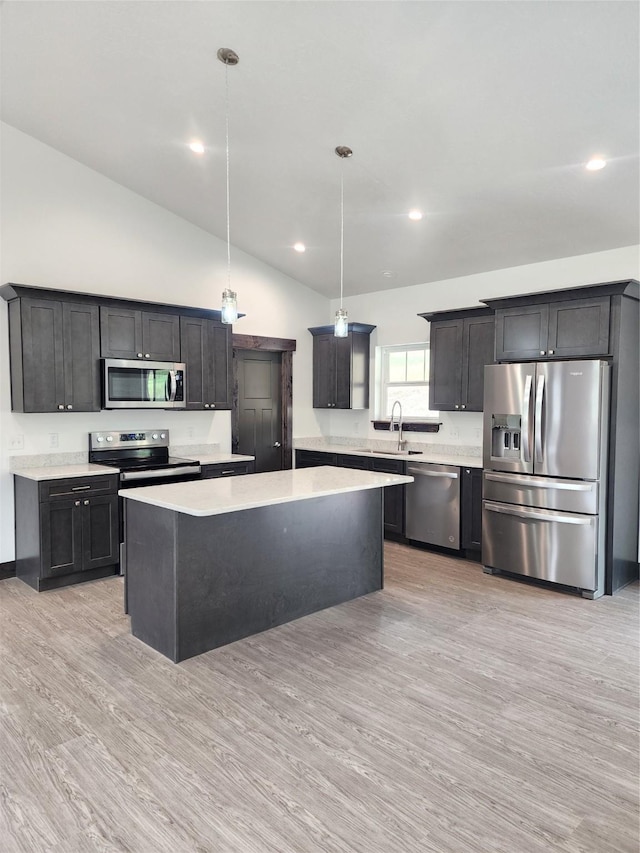 kitchen featuring sink, a center island, light hardwood / wood-style flooring, pendant lighting, and stainless steel appliances