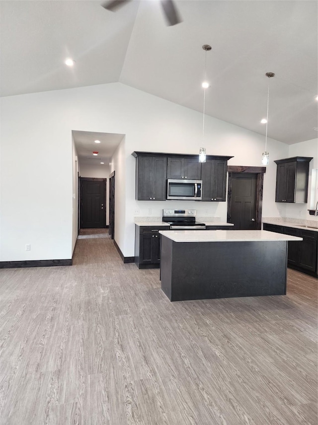 kitchen featuring a kitchen island, decorative light fixtures, ceiling fan, light hardwood / wood-style floors, and stainless steel appliances