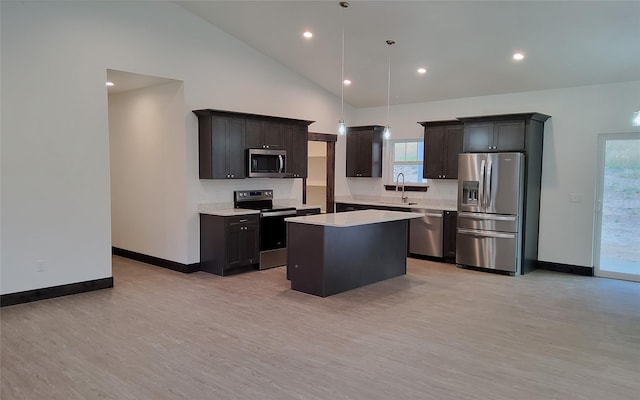 kitchen featuring pendant lighting, sink, appliances with stainless steel finishes, light hardwood / wood-style floors, and a kitchen island