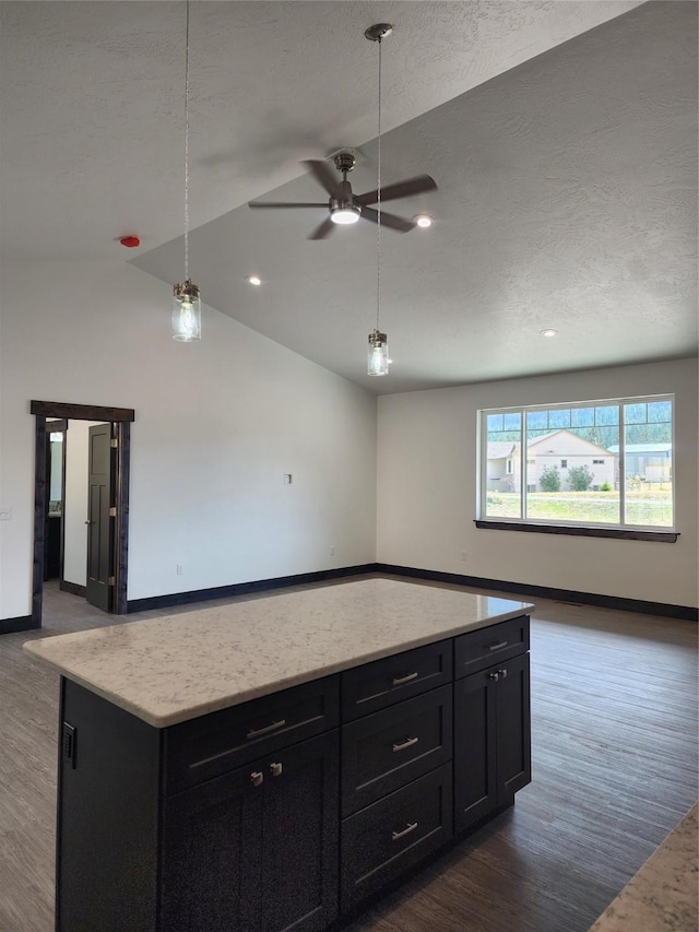 kitchen featuring lofted ceiling, decorative light fixtures, dark hardwood / wood-style floors, and a center island