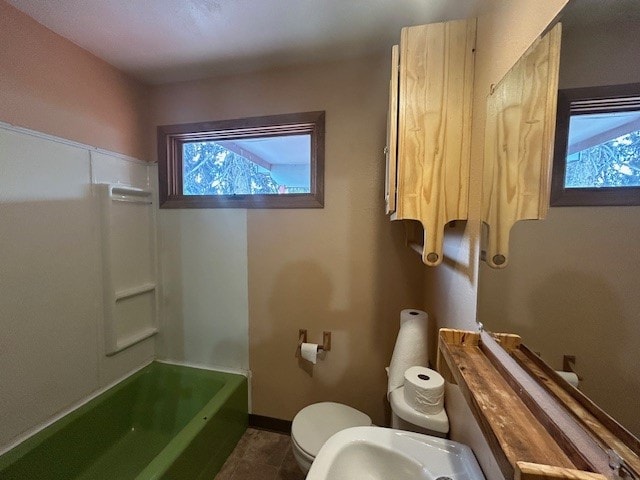 bathroom with plenty of natural light, toilet, and tile patterned flooring