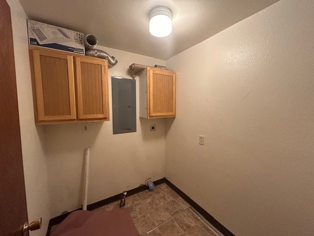 washroom featuring electric panel, electric dryer hookup, and cabinets