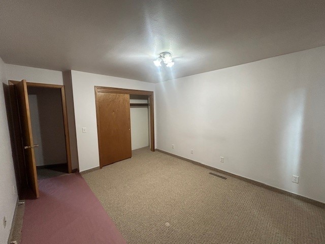 unfurnished bedroom featuring a closet and carpet flooring