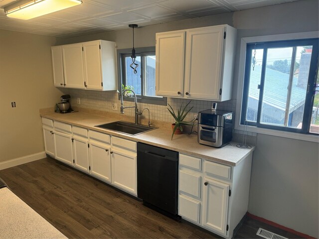 kitchen with dark hardwood / wood-style flooring, sink, pendant lighting, black dishwasher, and white cabinetry