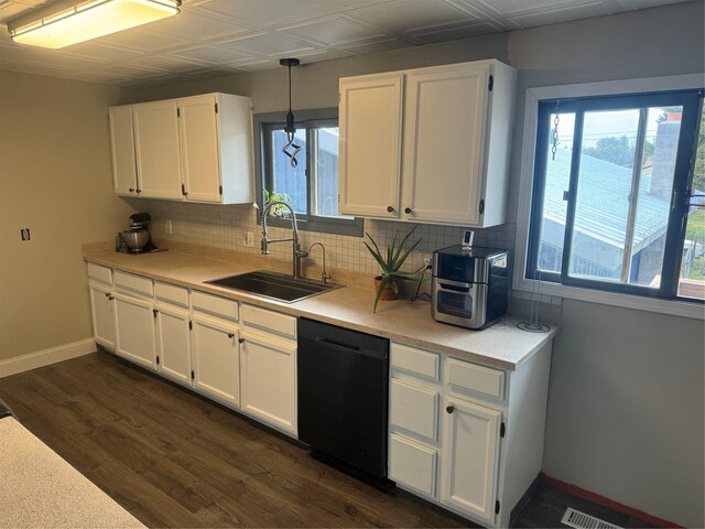 kitchen featuring white cabinets, black dishwasher, hanging light fixtures, and a healthy amount of sunlight