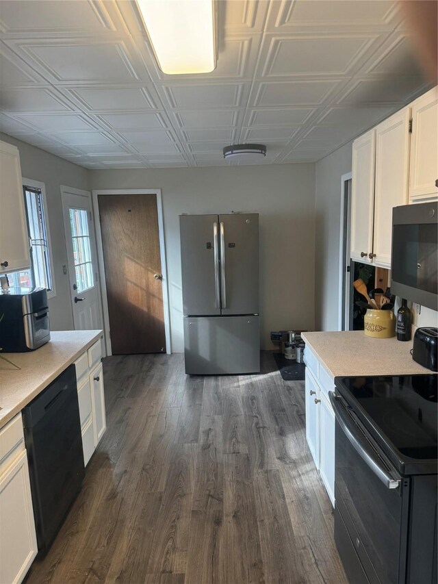 kitchen with white cabinets, stainless steel appliances, and dark wood-type flooring