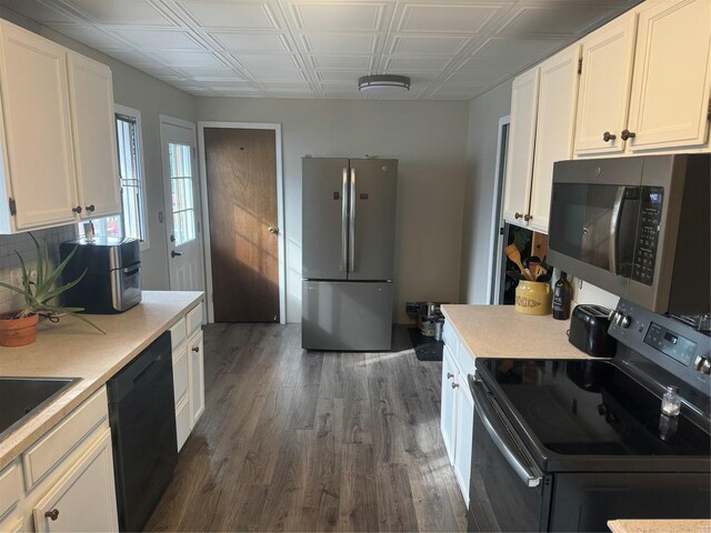 kitchen with dark hardwood / wood-style flooring, white cabinetry, and black appliances