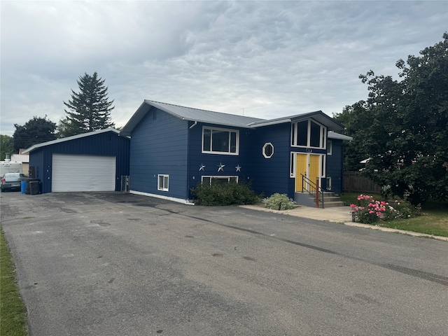 view of front of home with a garage and central air condition unit